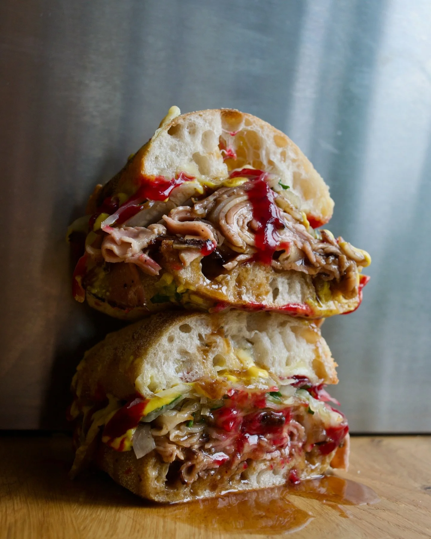 The Naughty Piggy.

Black garlic and treacle brined pork shoulder, slow roasted in the wood fire oven, sliced wafer thin and dipped in pork jus.

Smoked mozzarella, wild garlic sauerkraut, our global mix of mustards, and cranberry jam.

Everything pu