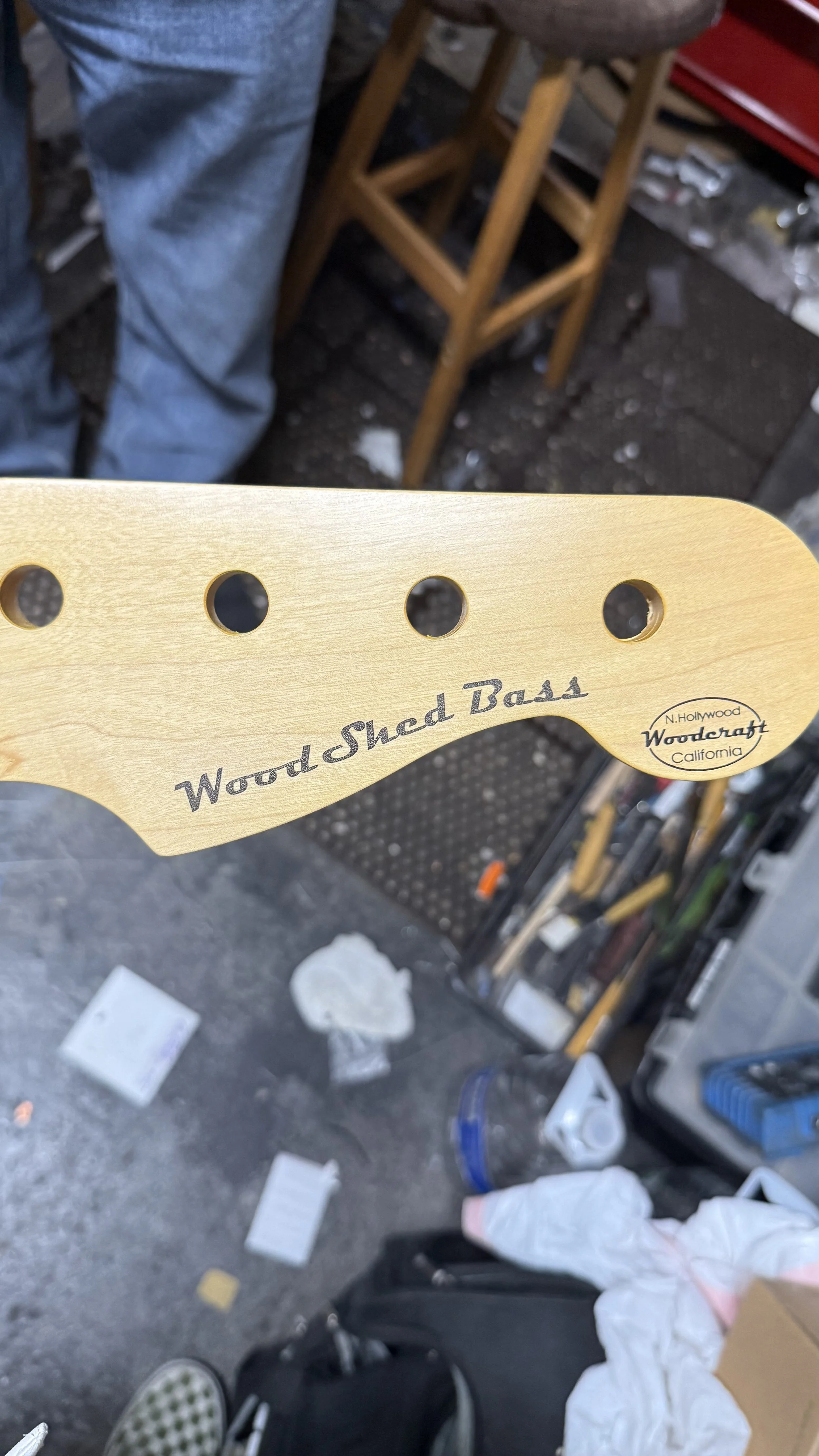 Headstock of a Wood and Shred Bass guitar with a label from Woodcraft California.