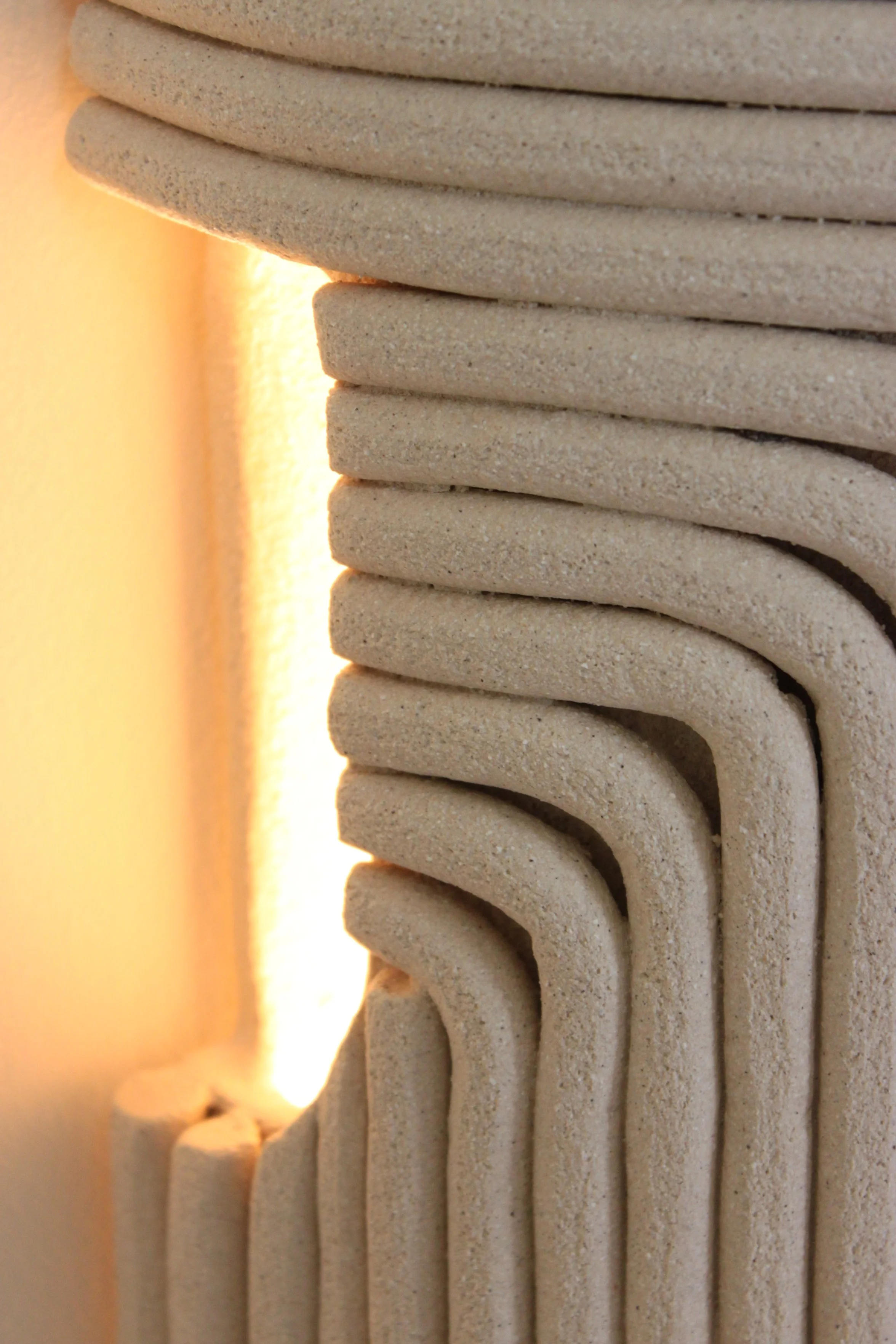 gros plan de l'applique en grès blanc chamotte. Texture minérale et pure. couleur sable.