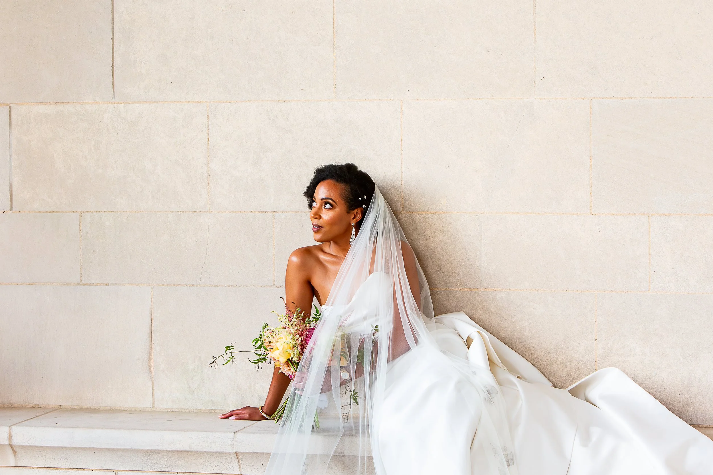 bride sitting with dress and veil arranged around her