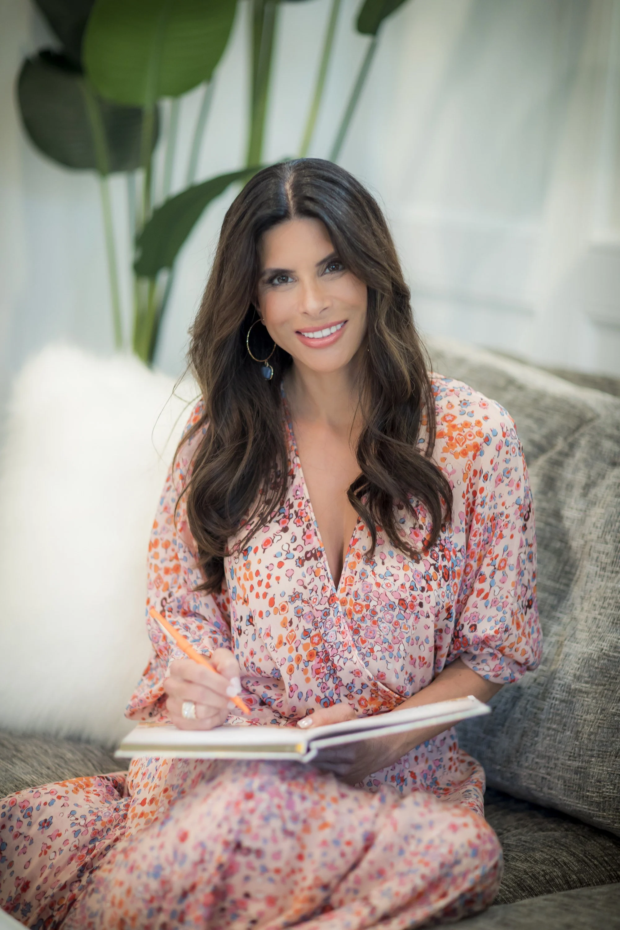 Teresa Williams, intuitive medium and sound practitioner, journaling on a couch in Tampa