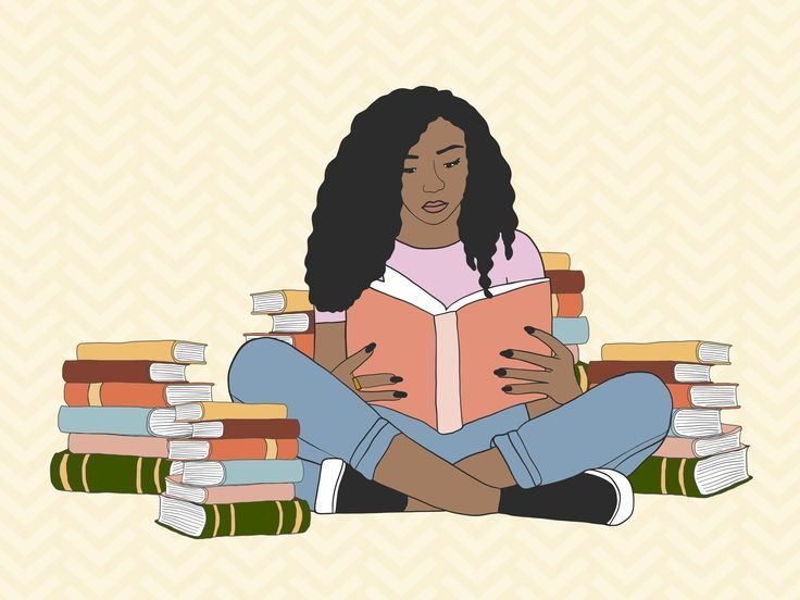 Young woman sitting cross-legged surrounded by stacks of books, reading a book.