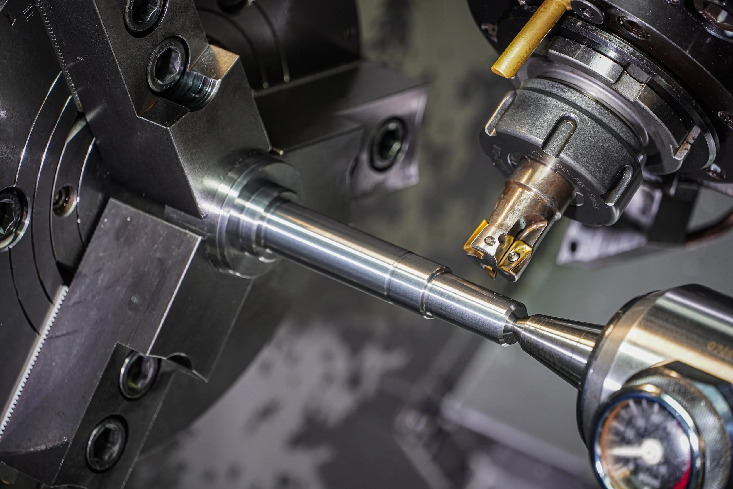 Close-up of a CNC lathe machining a metal rod with precision cutting tools.