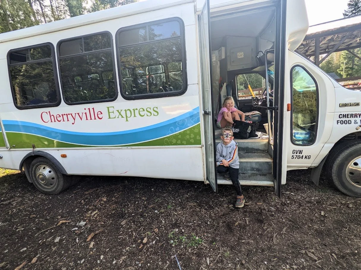 Cherryville Express Bus with two scholl aged children sitting on the bus steps