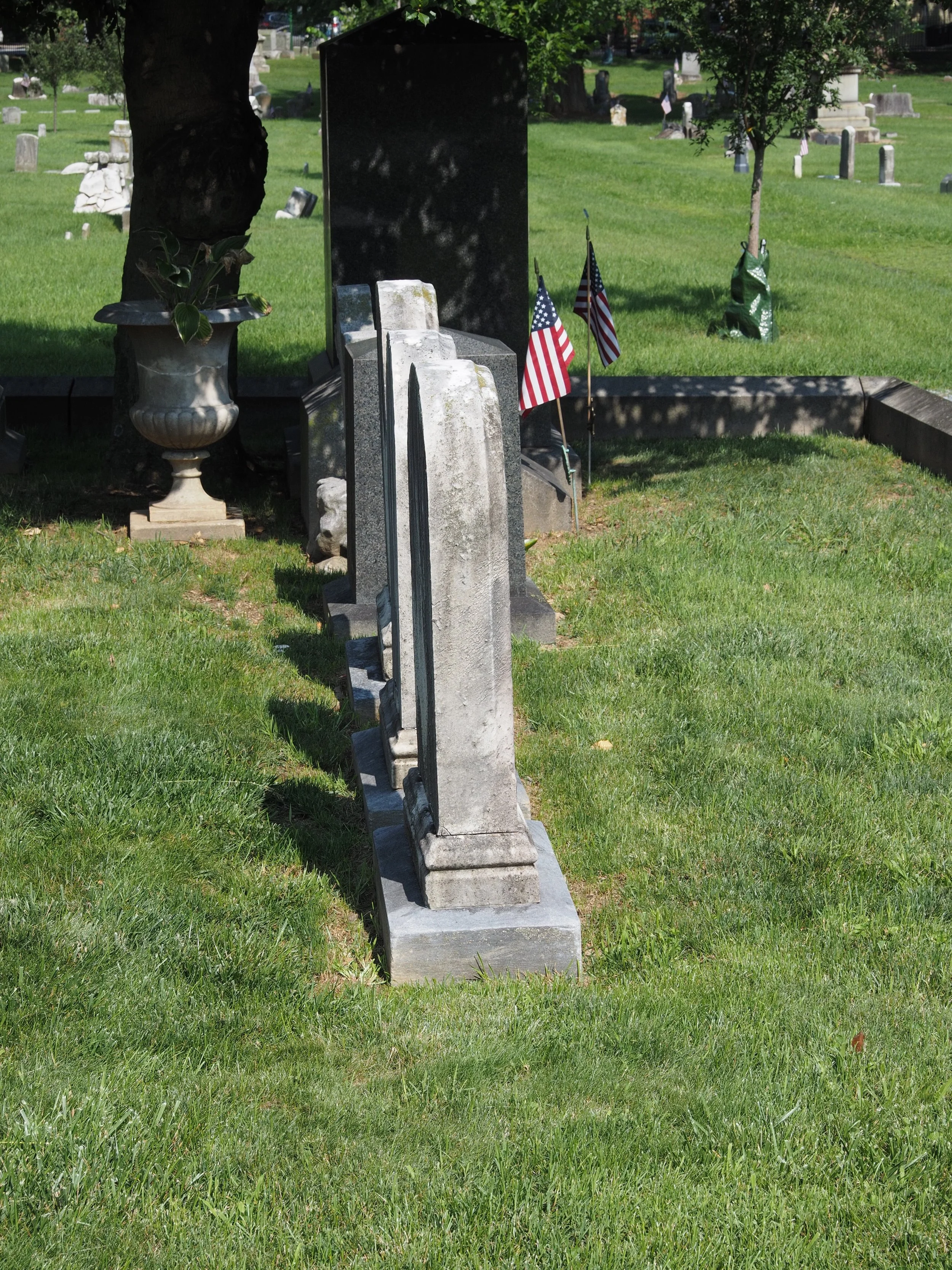 Headstones throughout the plot are leveled on a tamped gravel bed.