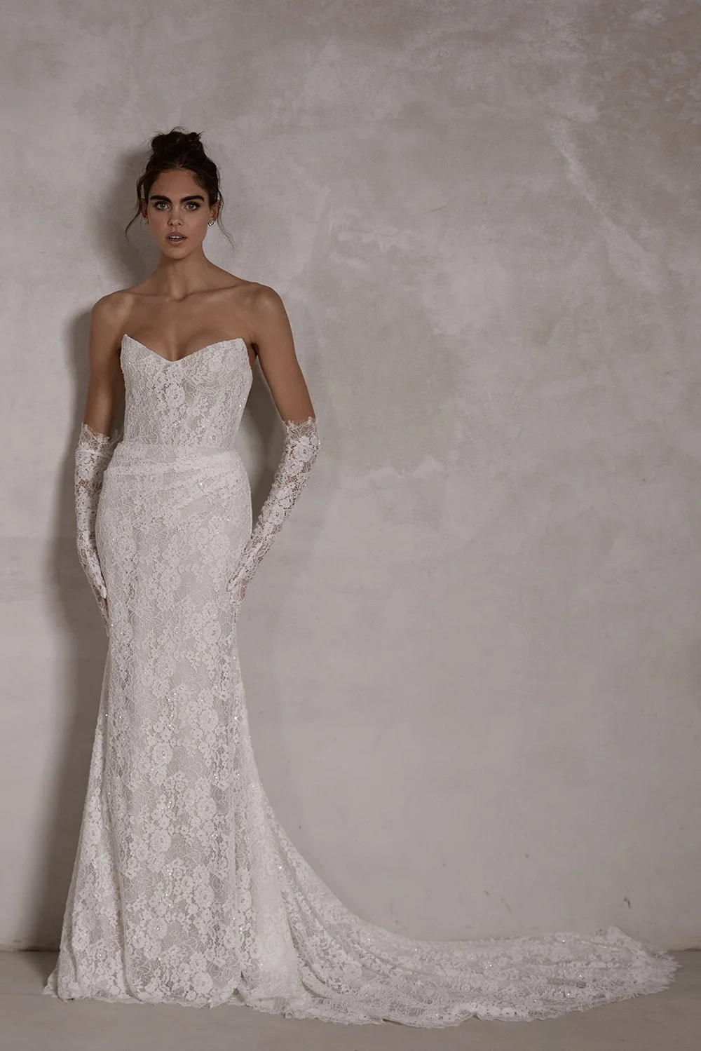 Soraya wedding gown featuring hand-beaded vintage-inspired lace, a structured boned corset with built-in push-up cups, a fitted mermaid skirt with optional front ruching, covered buttons down the train, and optional matching lace gloves.
