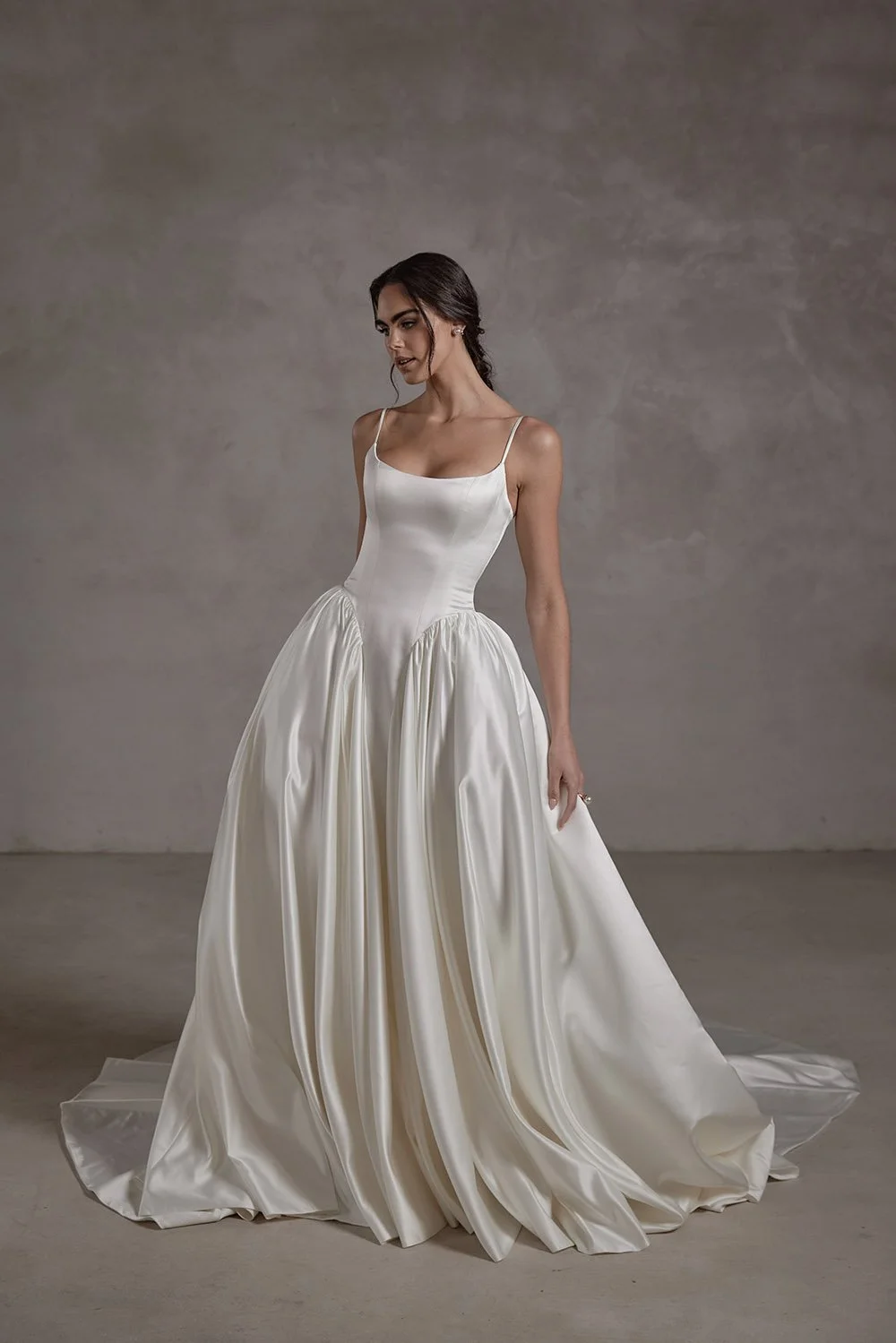 Ophelia wedding gown in ivory duchess satin, featuring a structured boned bodice with built-in cups, a ruched basque waist, lace-up back, and a voluminous mermaid silhouette with a detachable petticoat and elegant train.