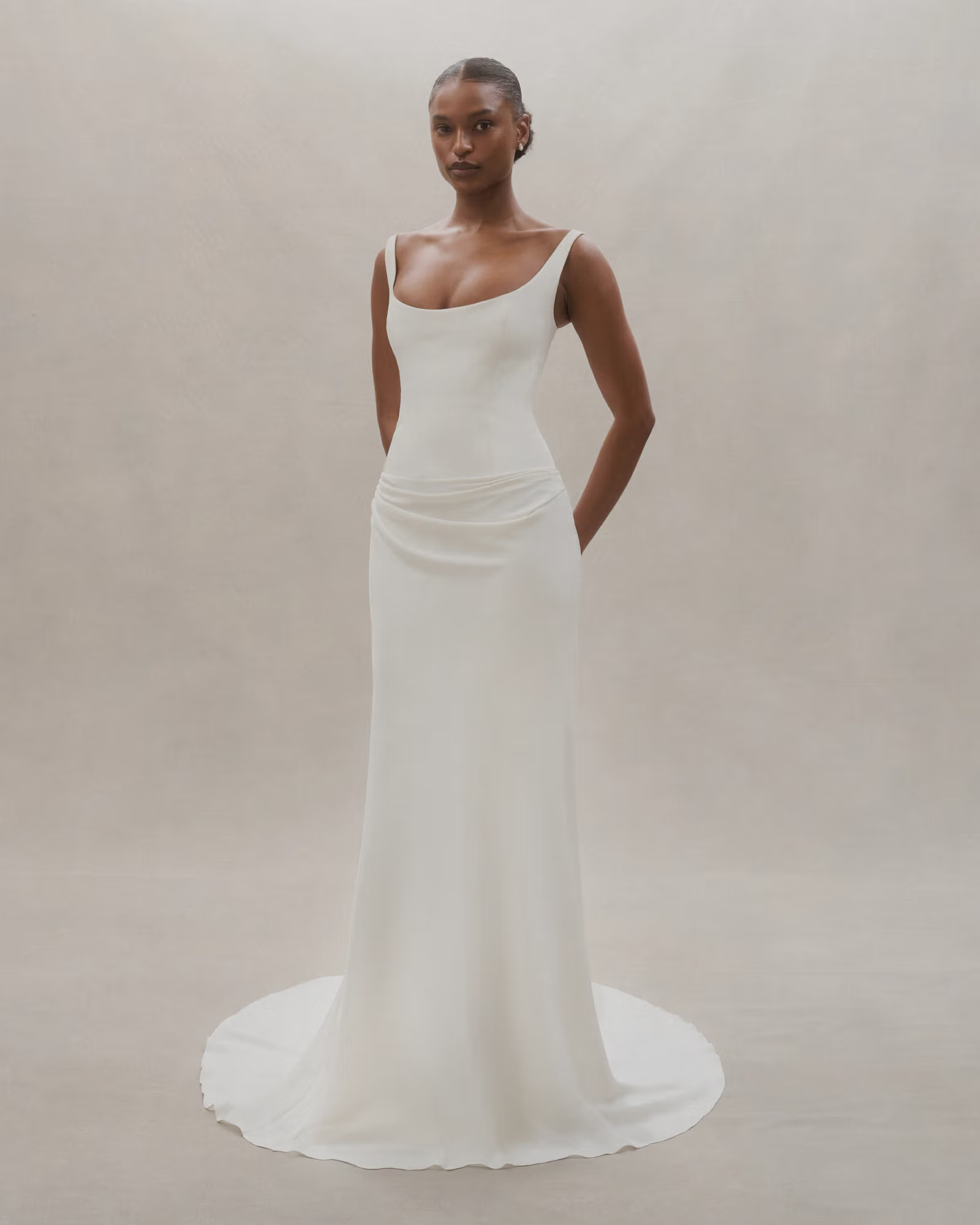 Solene features a soft scoop neckline and structured drop-waist bodice, accompanied by an effortlessly draped skirt.