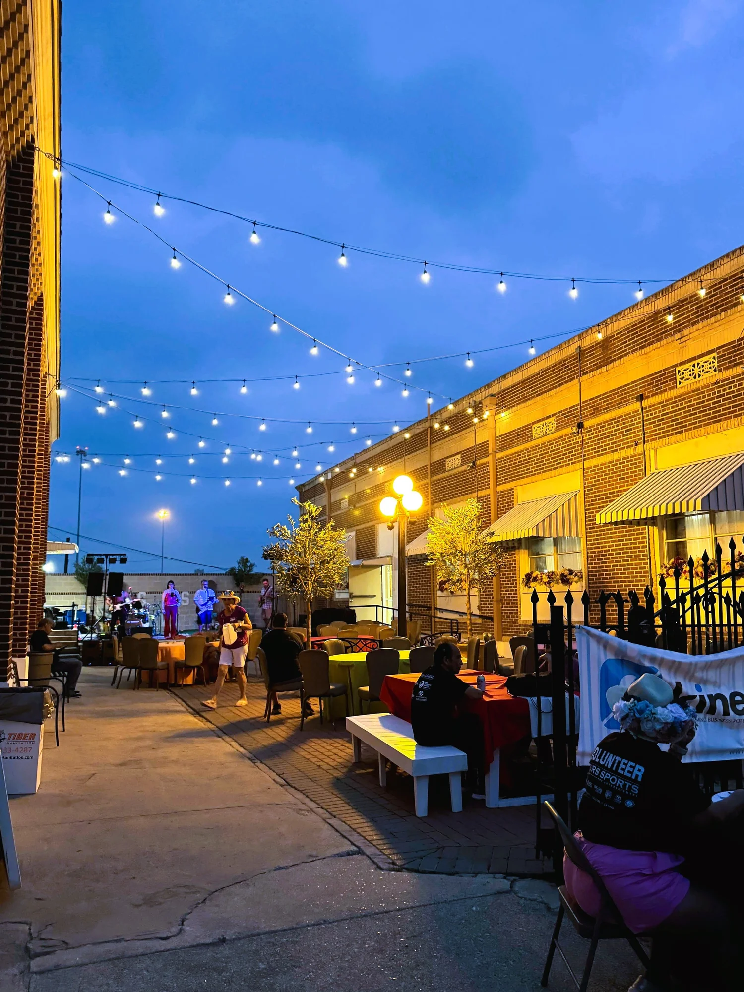 The Italian Hall courtyard at night, lit with string lights, guests at tables and a band on a small stage