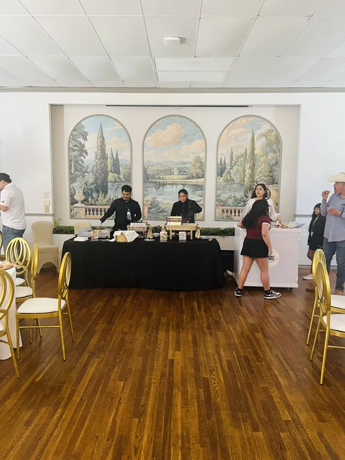 Guests at a buffet in front of landscape murals