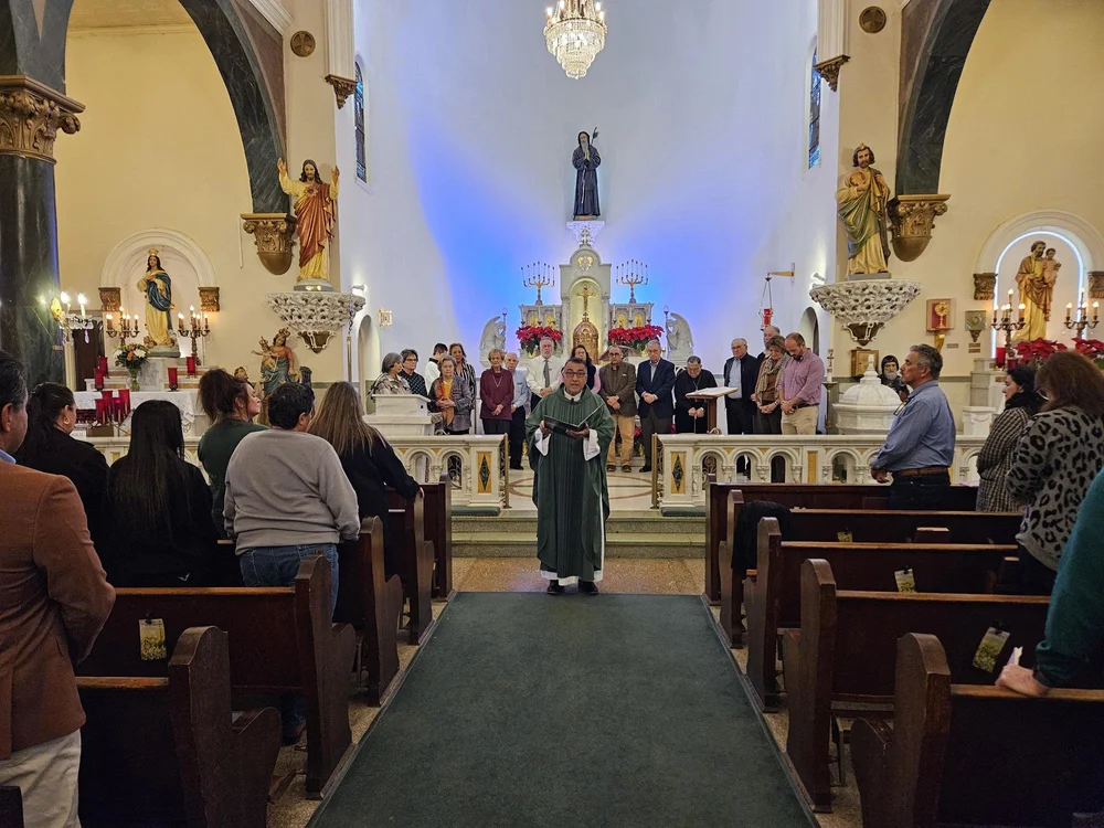 A Mass inside the Church of San Francesco di Paola, with the congregation in wooden pews before the altar