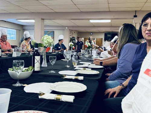 A dinner party in the Venice Room with guests in chef hats