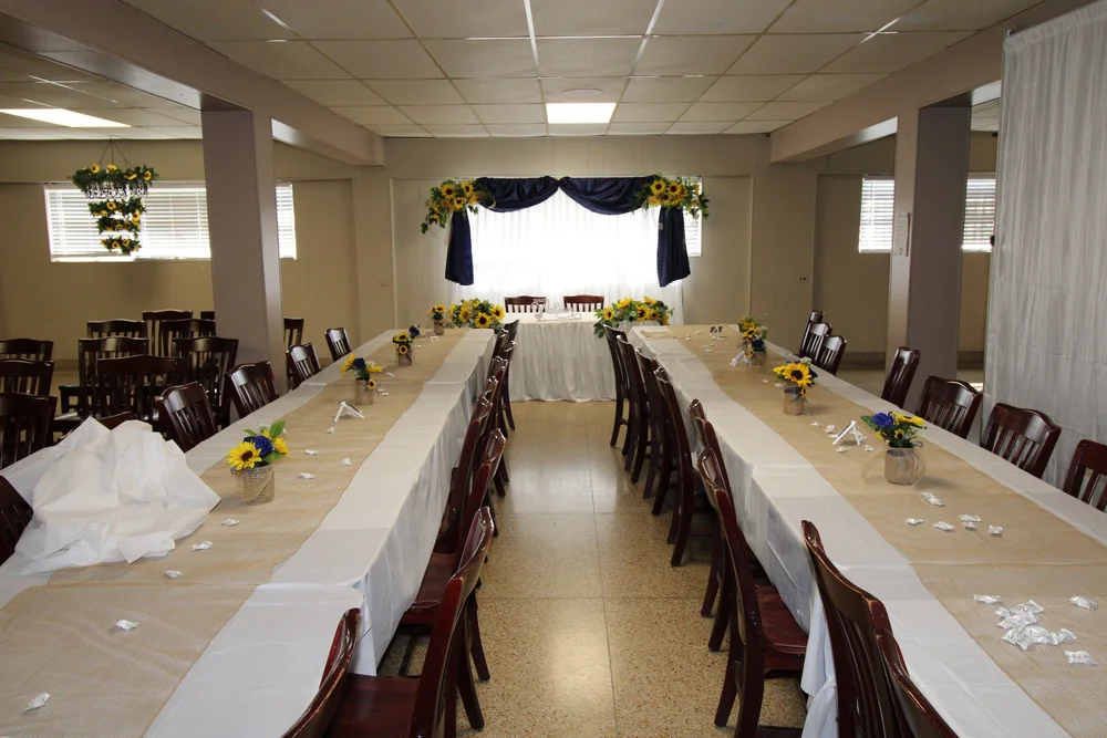 The Venice Room set with long banquet tables, sunflower centerpieces and a head table