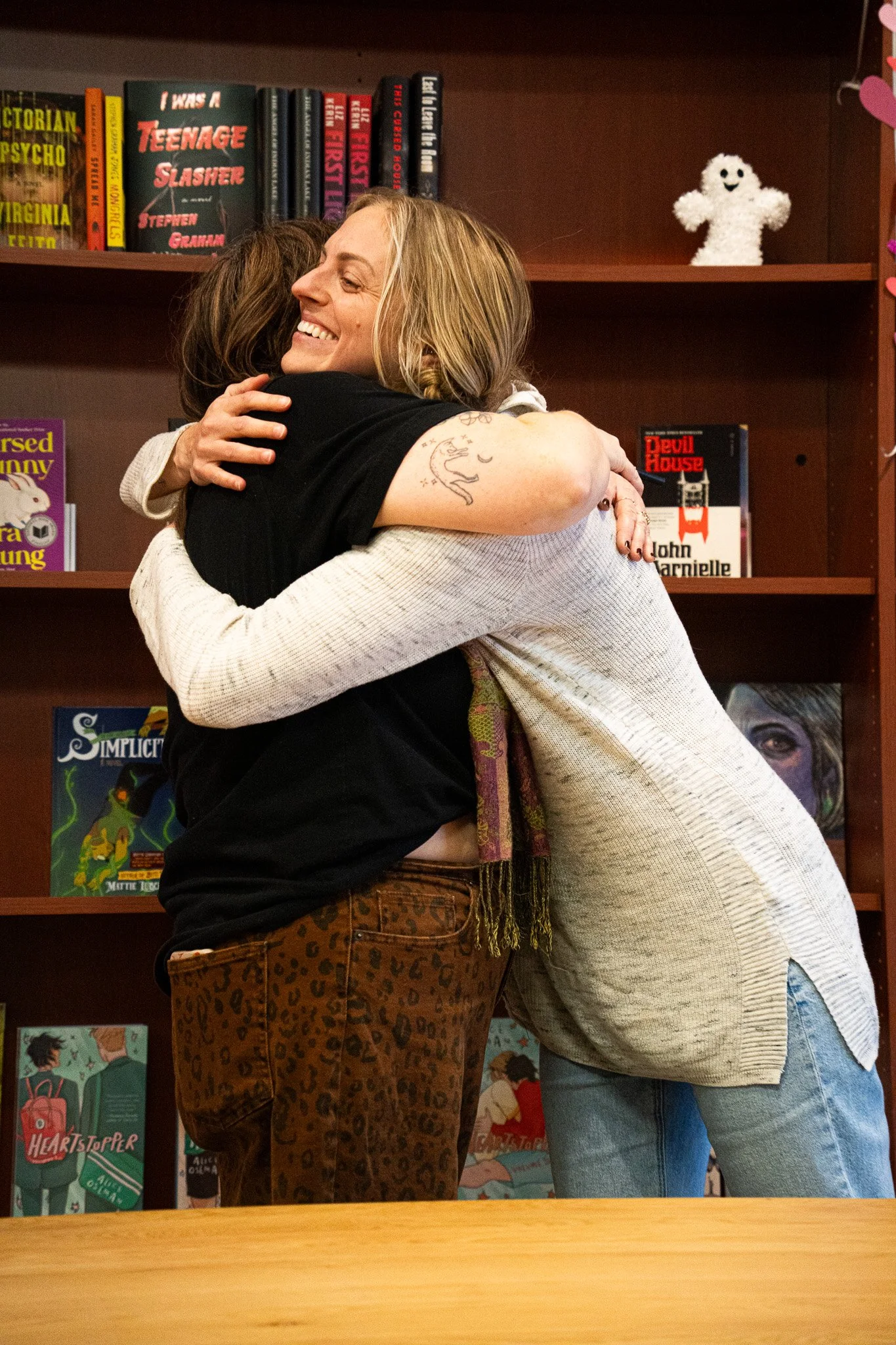 Christine Peffer giving Owner Sara Pulver of Dear Ollie and Co. a huge hug as they say hello and begin their preparations for this fun Kinshop event at A Novel Concept on October 24th, 2025 in Lansing Mich.