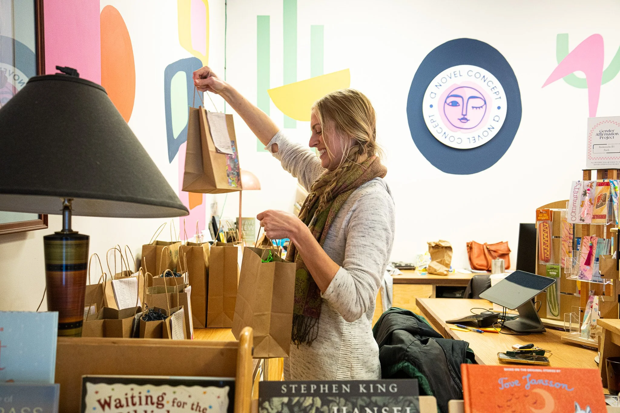 Christine Peffer alphabetically sorting Kinshop orders for people to pick up at their event at A Novel Concept on October 24th, 2025 in Lansing Mich.