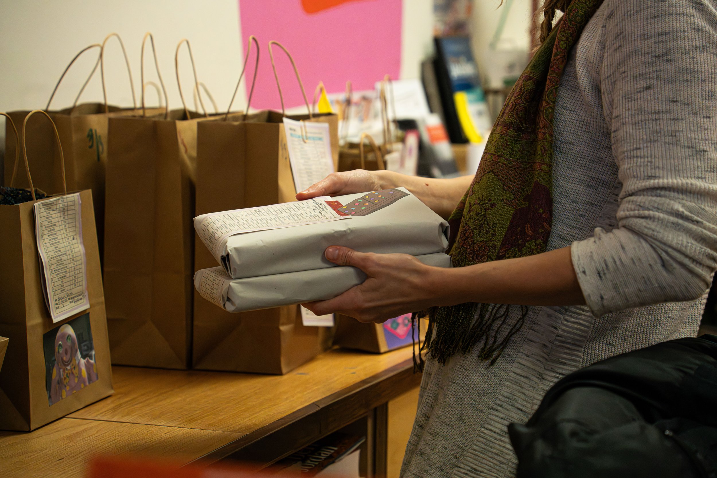 Christine Peffer double checking which orders go into each bag for their customers during their Kinshop event prep at A Novel Concept on October 24th, 2025 in Lansing Mich.