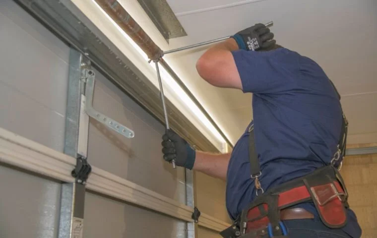 Garage door technician inspecting overhead tracks and components during a professional garage door repair in Bunbury.