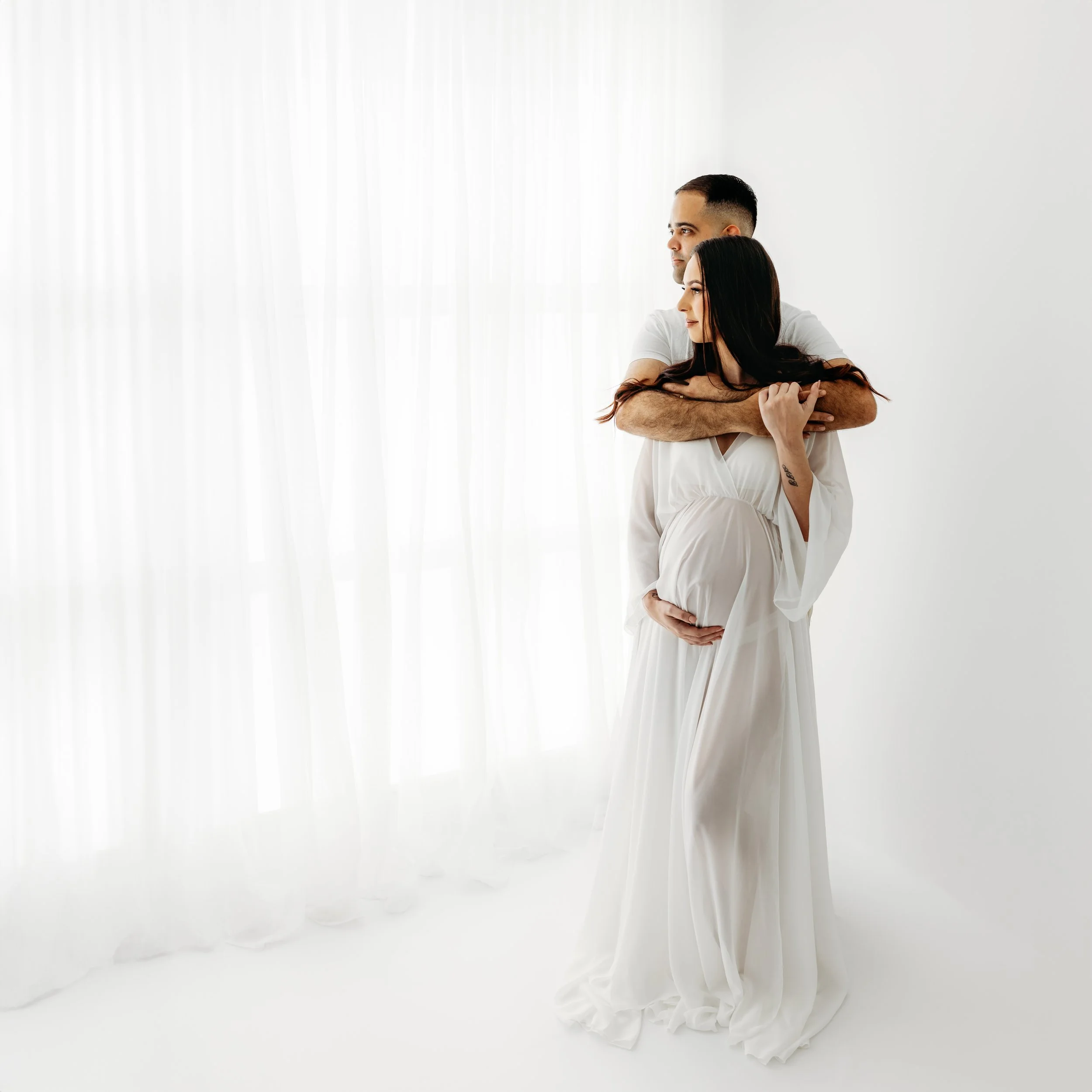 Expectant parents together during a relaxed studio maternity photography session in Perth.