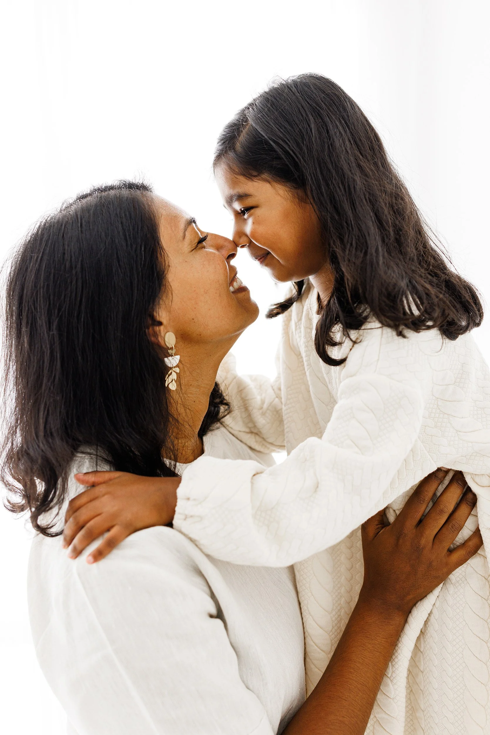 Mum holding her older daughter close during a Motherhood Mini Session