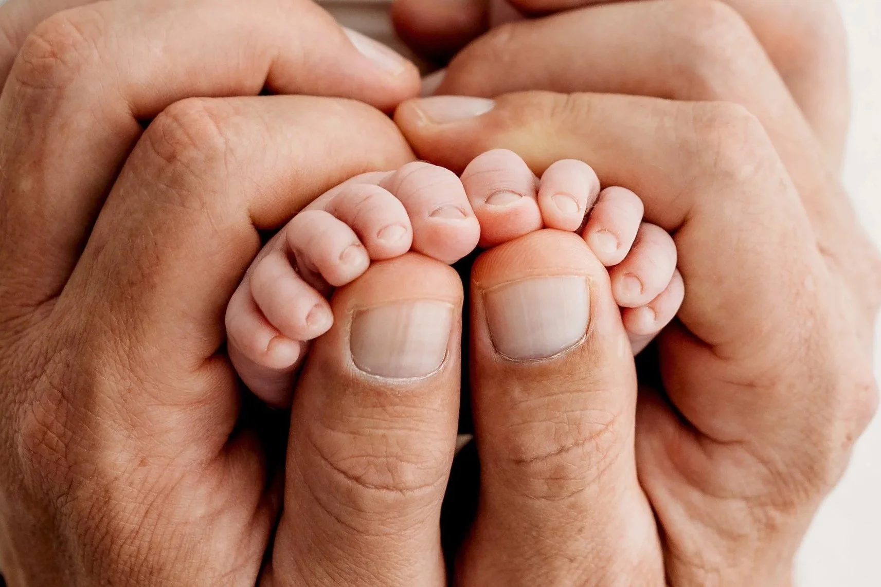 Close-up photograph of a newborn baby’s tiny feet during a studio newborn session.