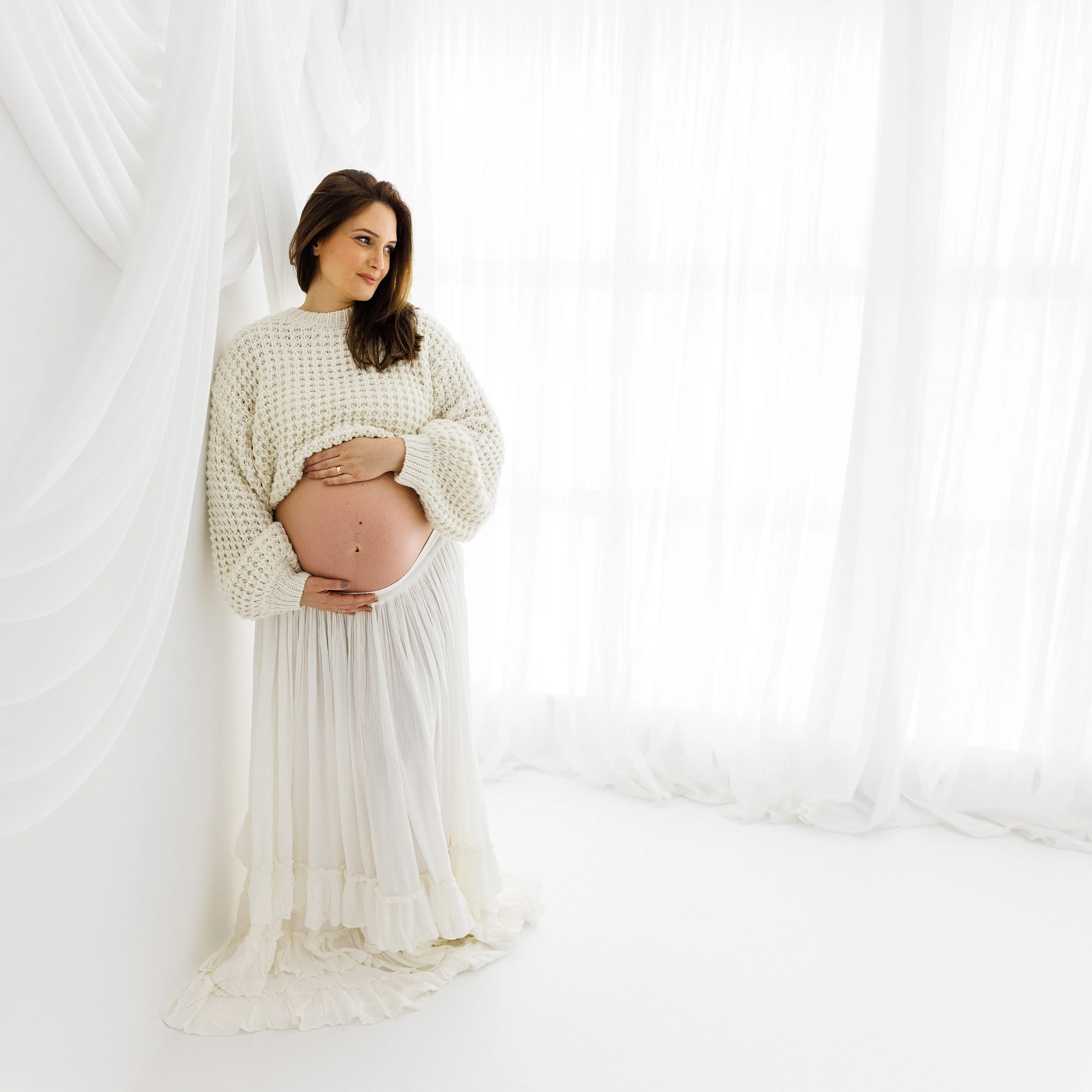 Side-profile maternity portrait celebrating an expectant mum and her growing baby bump.