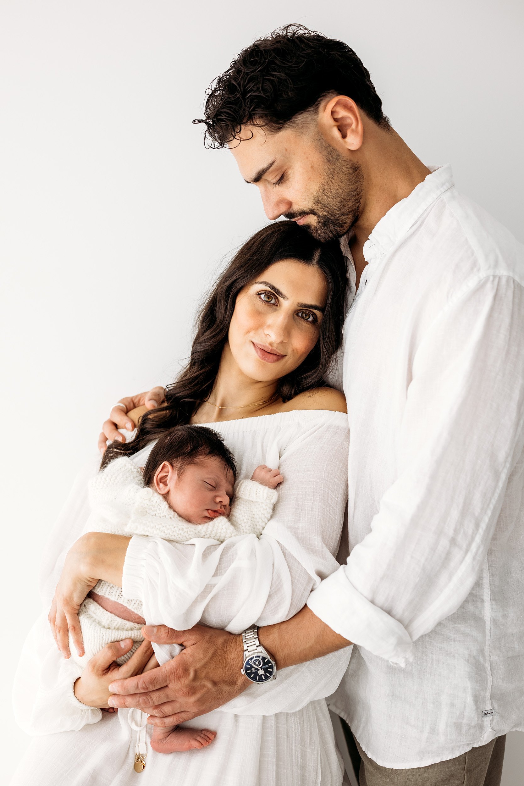Mum and Dad cuddling their newborn baby during a family newborn photography session in Perth’s Swan Valley.