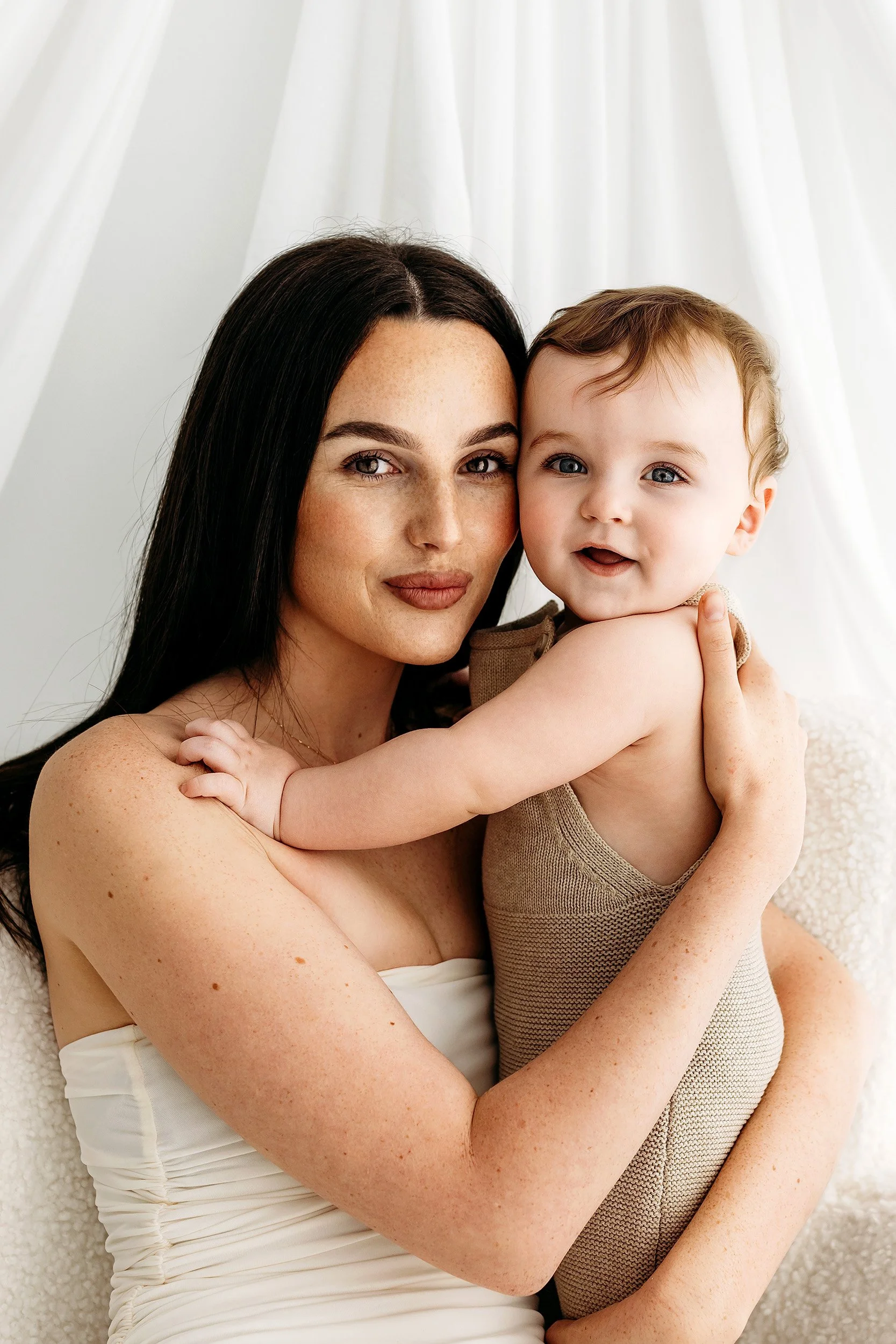 Mum cuddling her smiling baby during a studio photography session in Perth