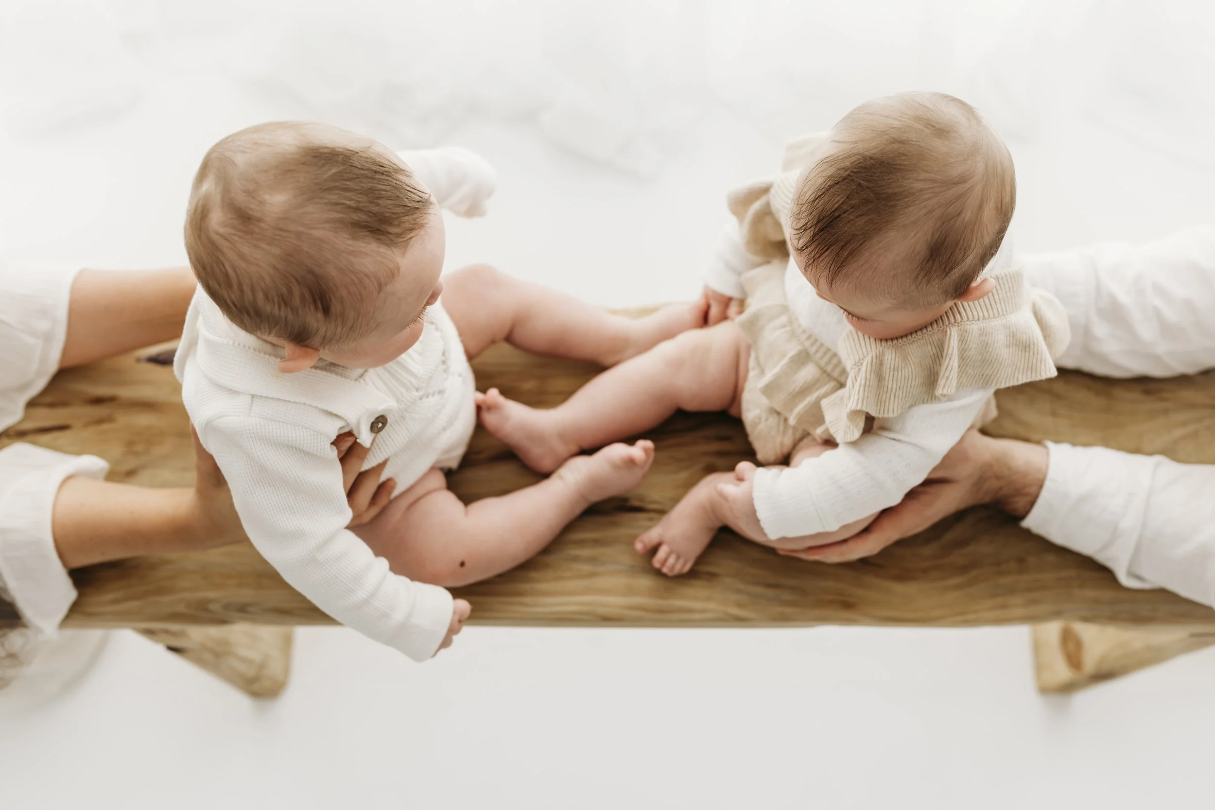 Two young siblings sitting together during a relaxed baby photography session in Perth.