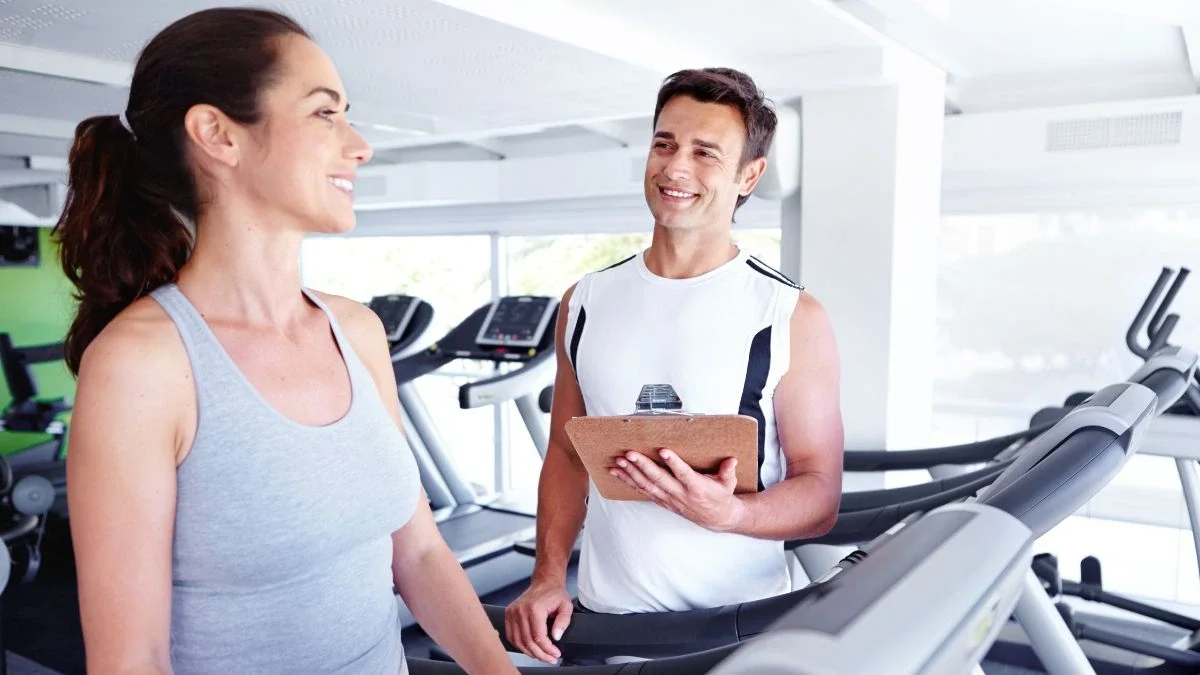 Beginner personal training session with clients performing strength and mobility exercises in a gym