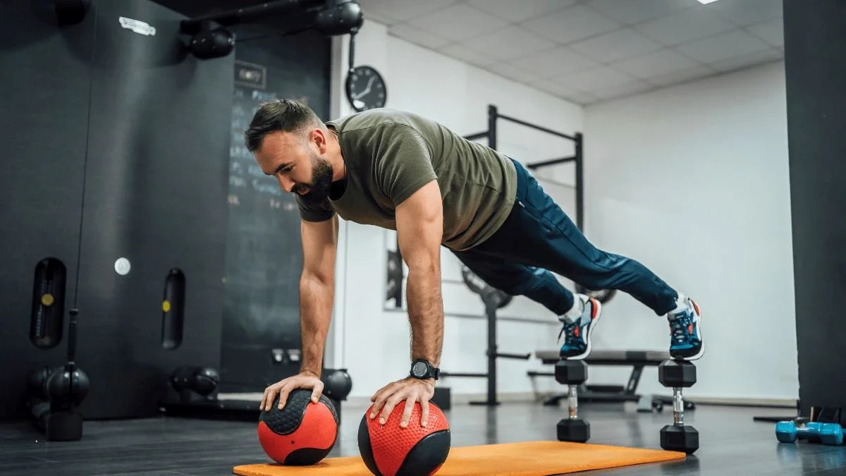 Male Plank On Balls and Dumbbells