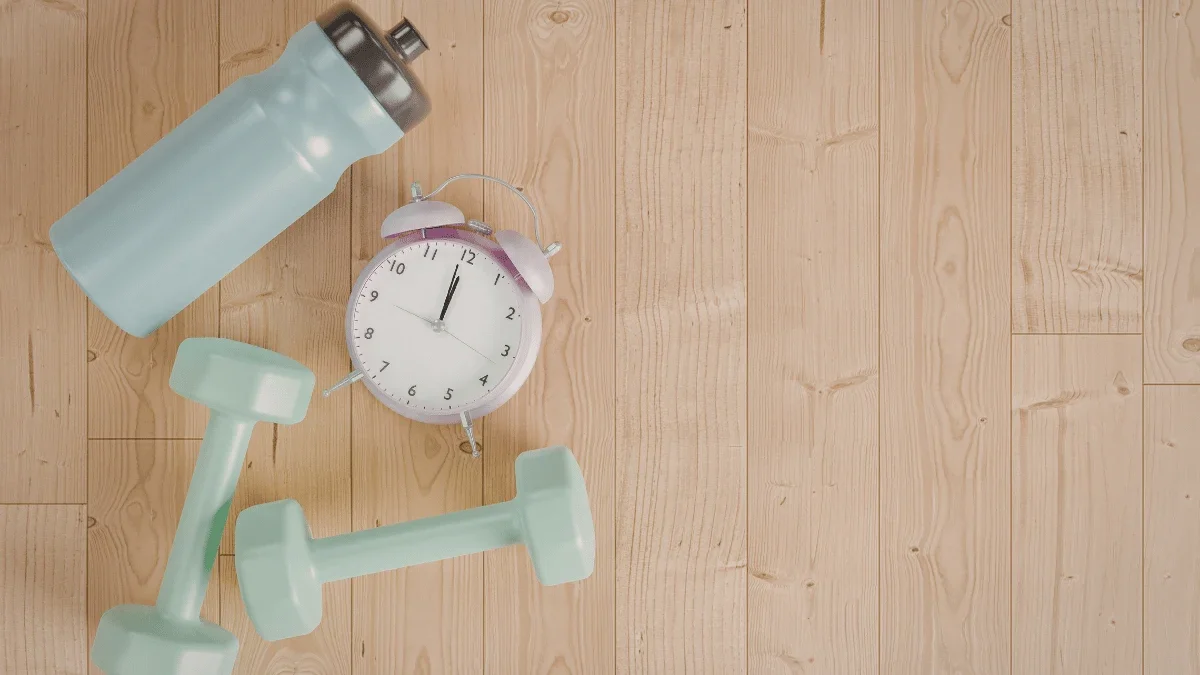 Dumbbells water bottle and clock representing quick and efficient lunchtime workout routine