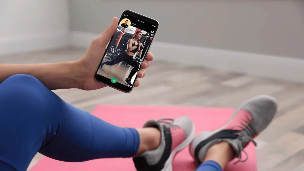Woman Sitting on floor looking at fitness app