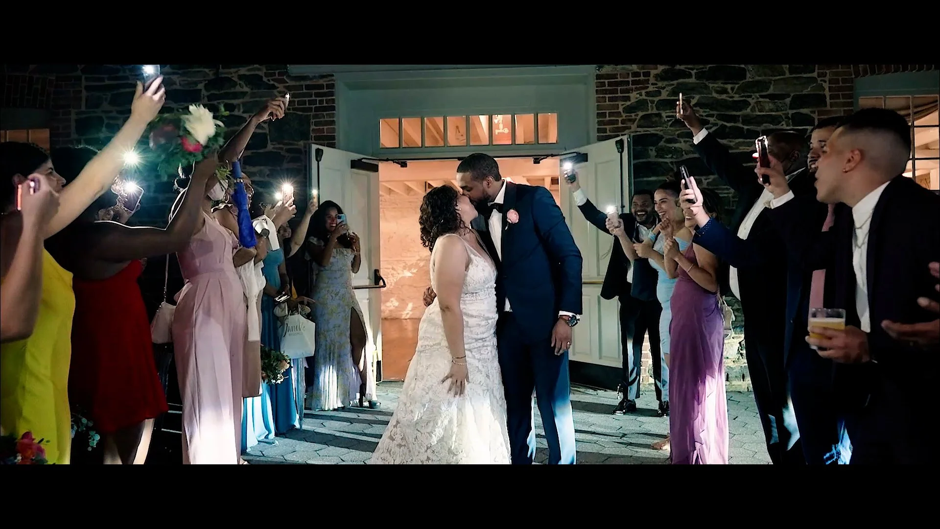 A final kiss between bride and groom during their exit at Stone Mill in New York Botanical Garden.