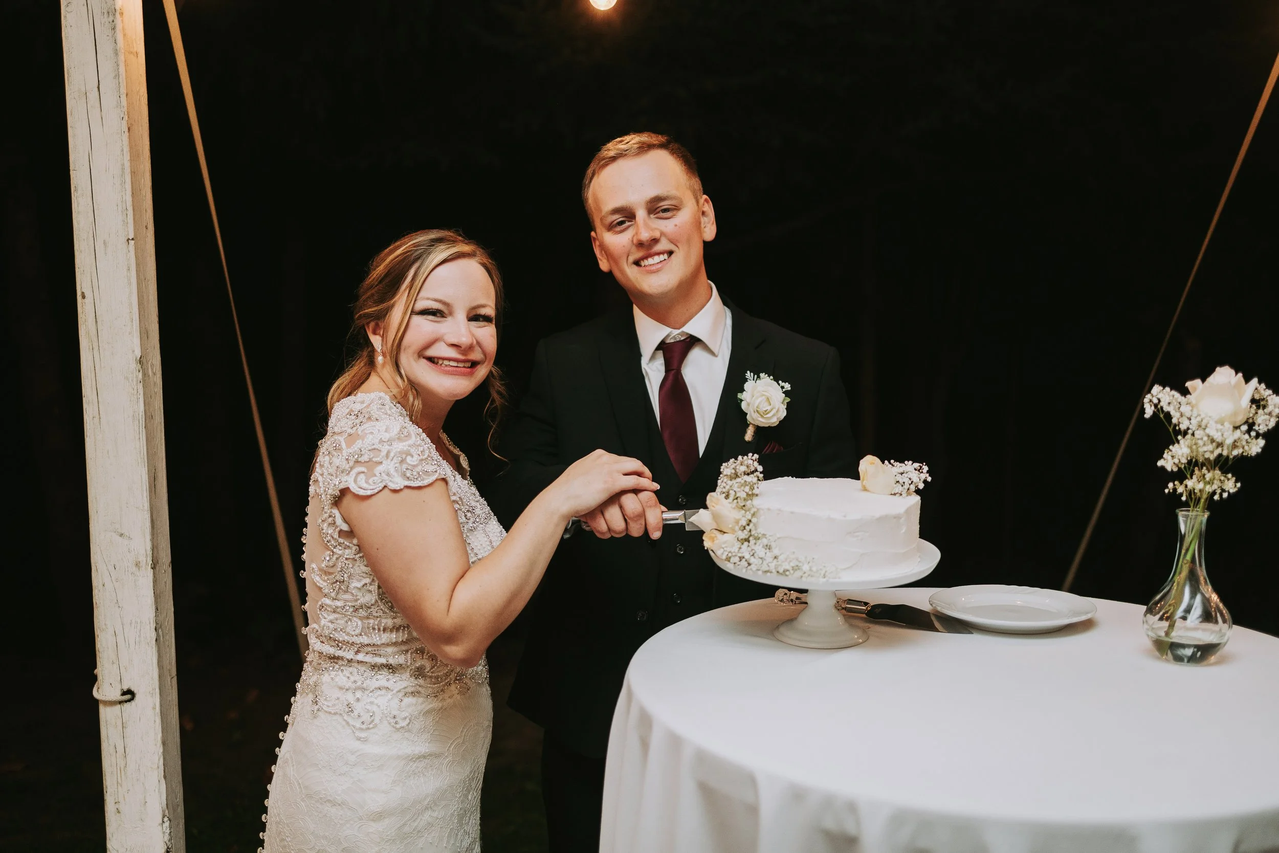 A bride and groom cutting a wedding cake at their reception.
