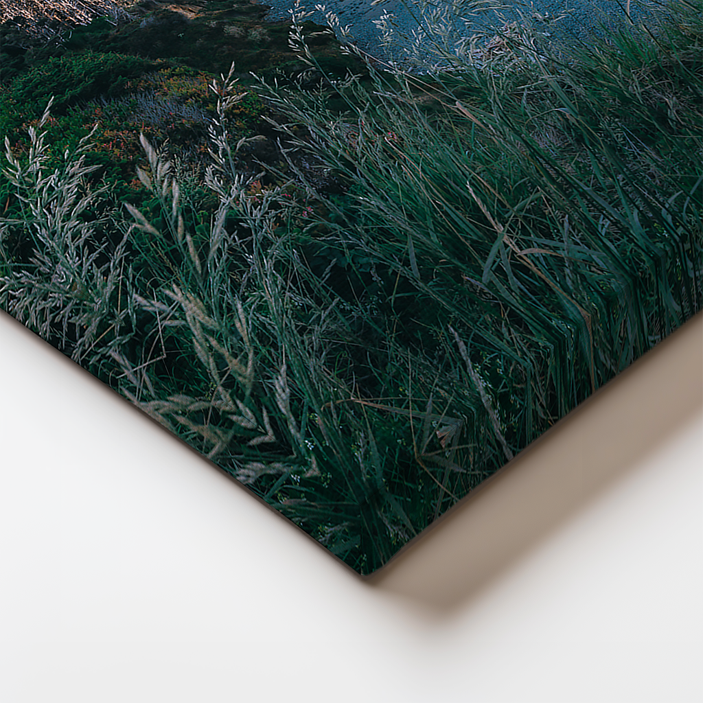 Detail view of the canvas print edge showing brush-textured finish and wrap-around image of coastal cliffs.