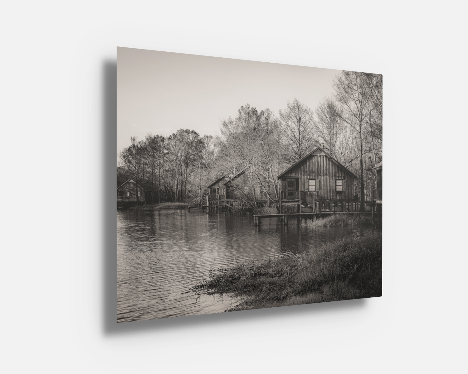 Metal print with bold contrast showing serene bayou cabins and still water reflections in timeless black and white.