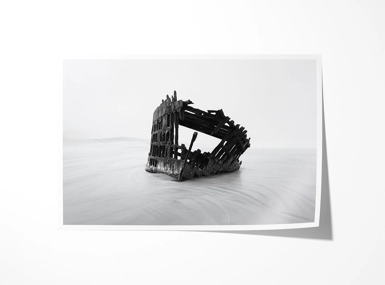 Fine art print of a weathered shipwreck emerging from the sands of the Oregon coast in soft, minimalist tones.
