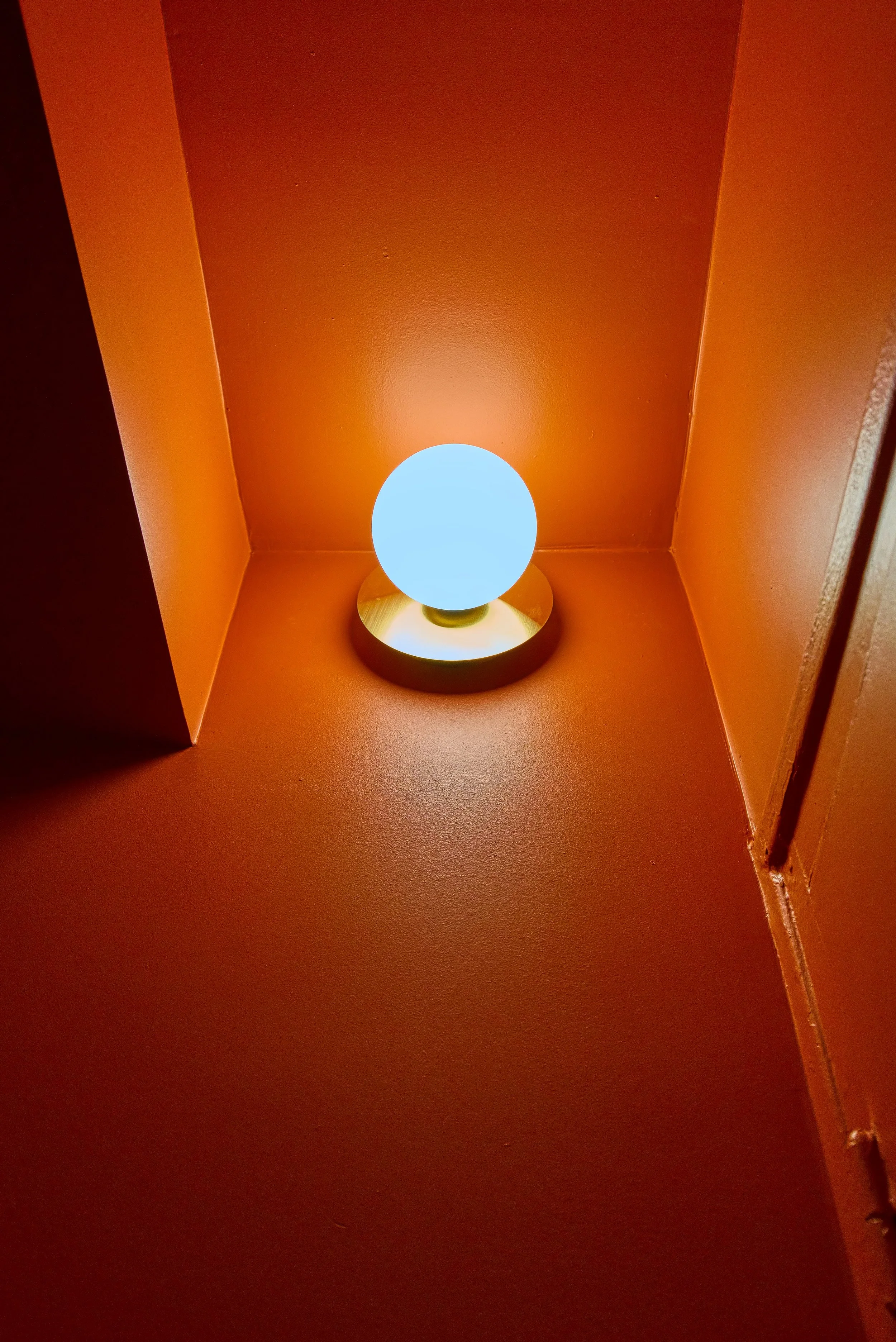 Une applique diffuse une lumière chaude et enveloppante dans cet espace tout en couleur