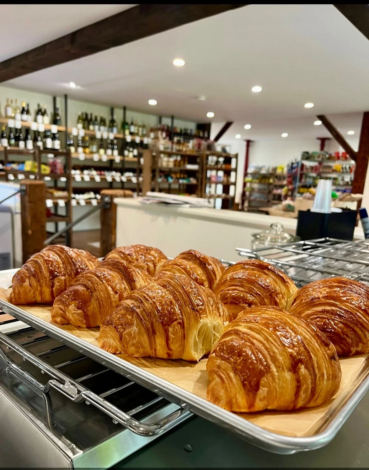 Freshly baked croissants on a tray in a cafe or bakery.