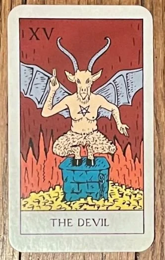 The Devil Tarot card, where a beast sits surrounded by flames