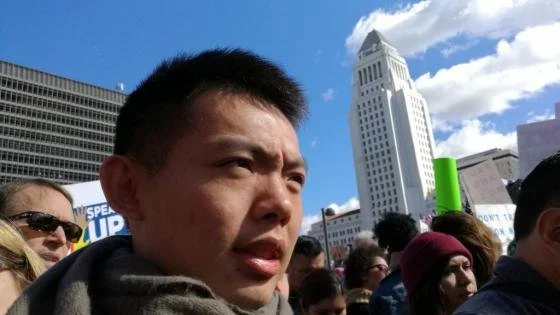 Han looking to the side with buildings in the background