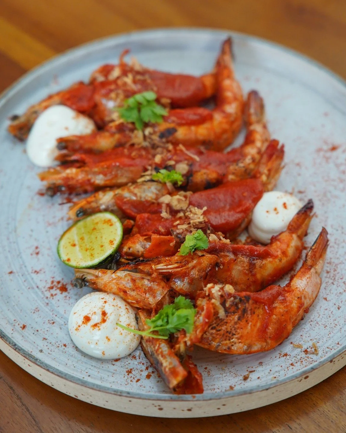Spice meets sea. Harissa prawn by the pool, a taste of fire and calm.

 #Lemanja #uluwatucafe #dinner #grill