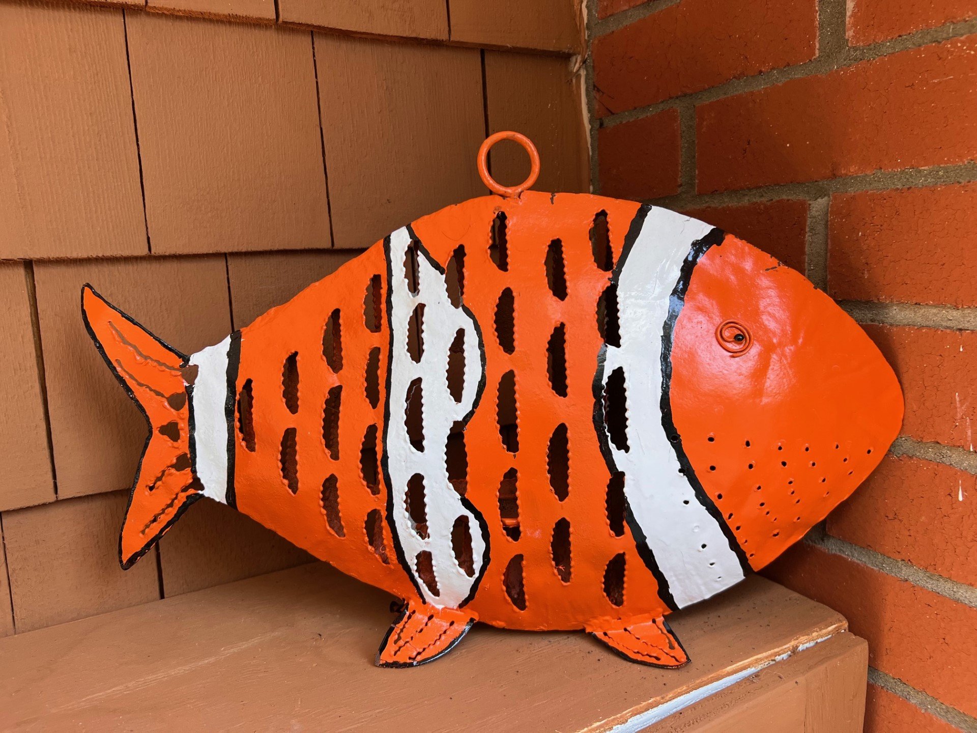 Roadside discarded black and rusty fish transformed into a Clownfish with a new spirit