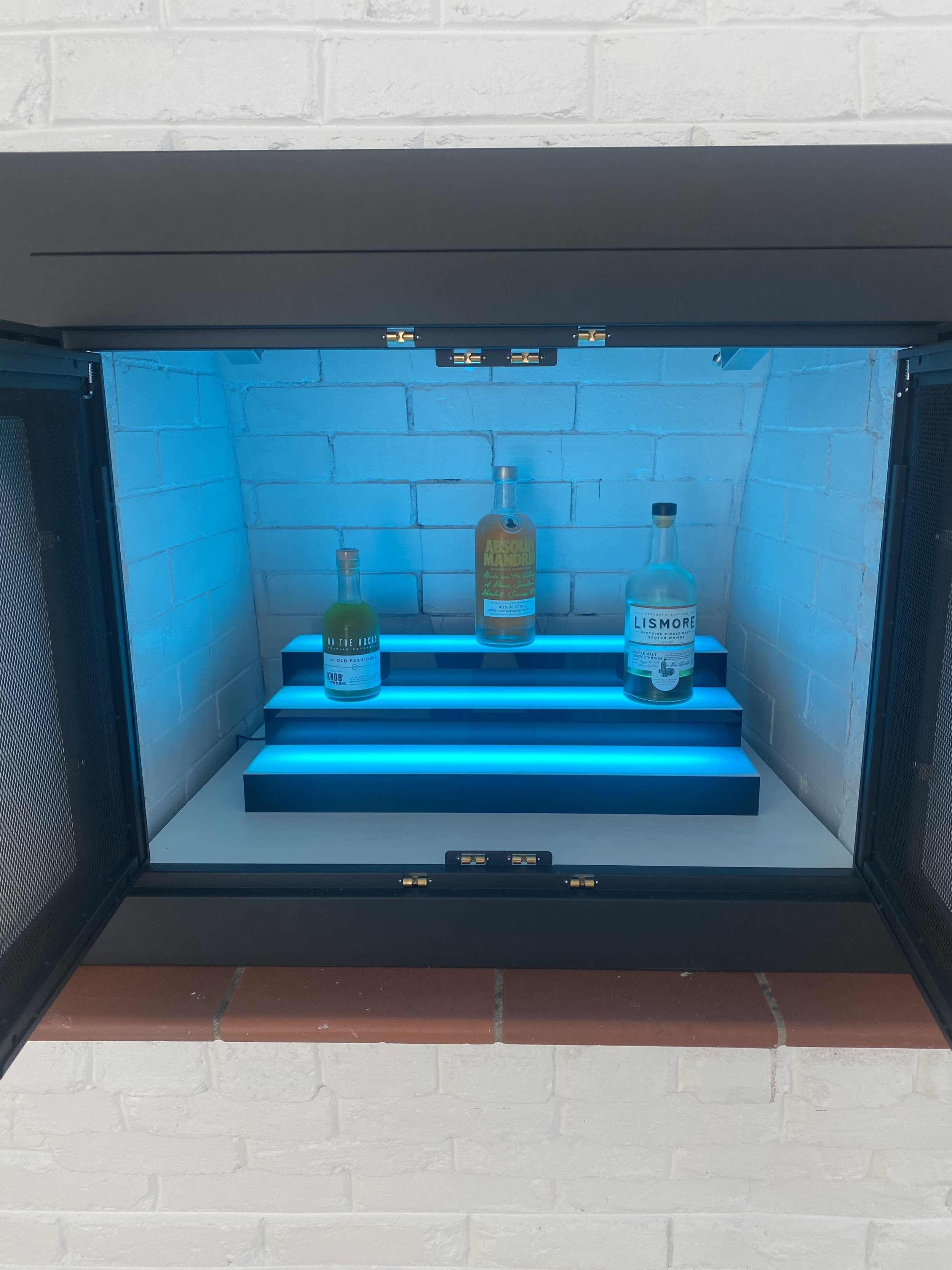 Repurposed unusable fireplace into an multi light LED infused family room bar