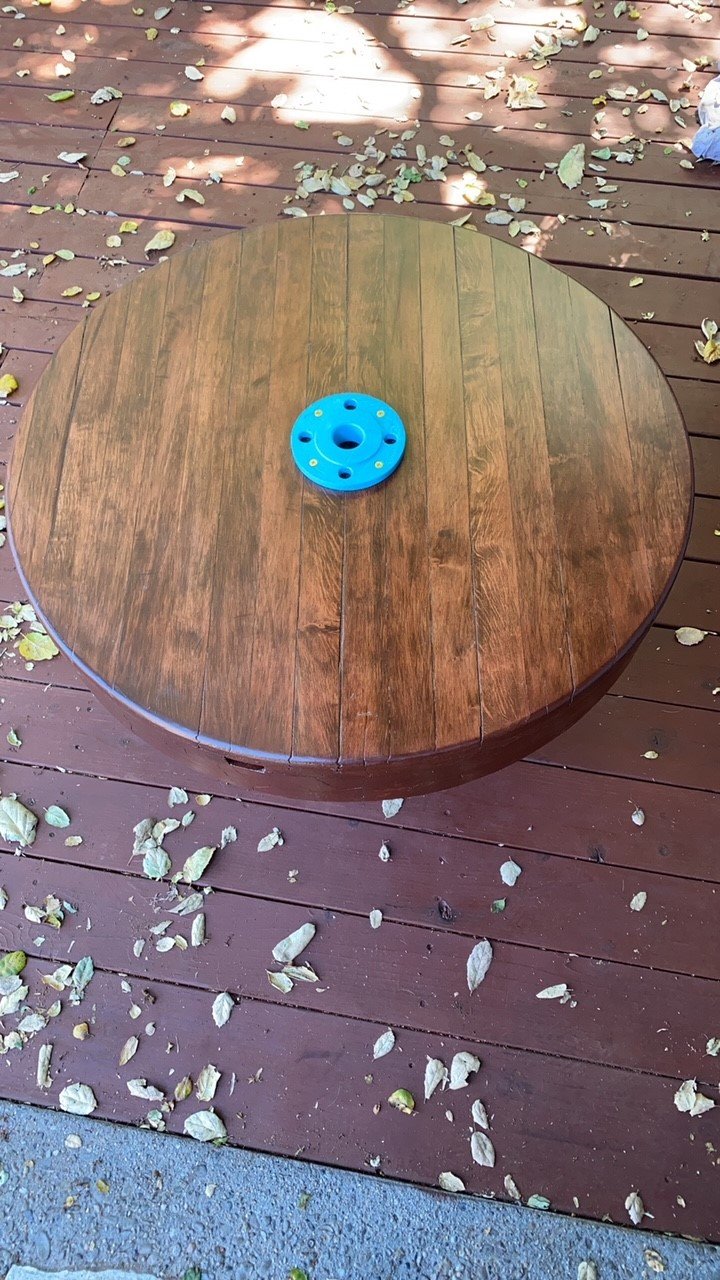 Old potter's wheel mounted on motorcycle lift to provide bar table, dining table, or couch table based on experience desired