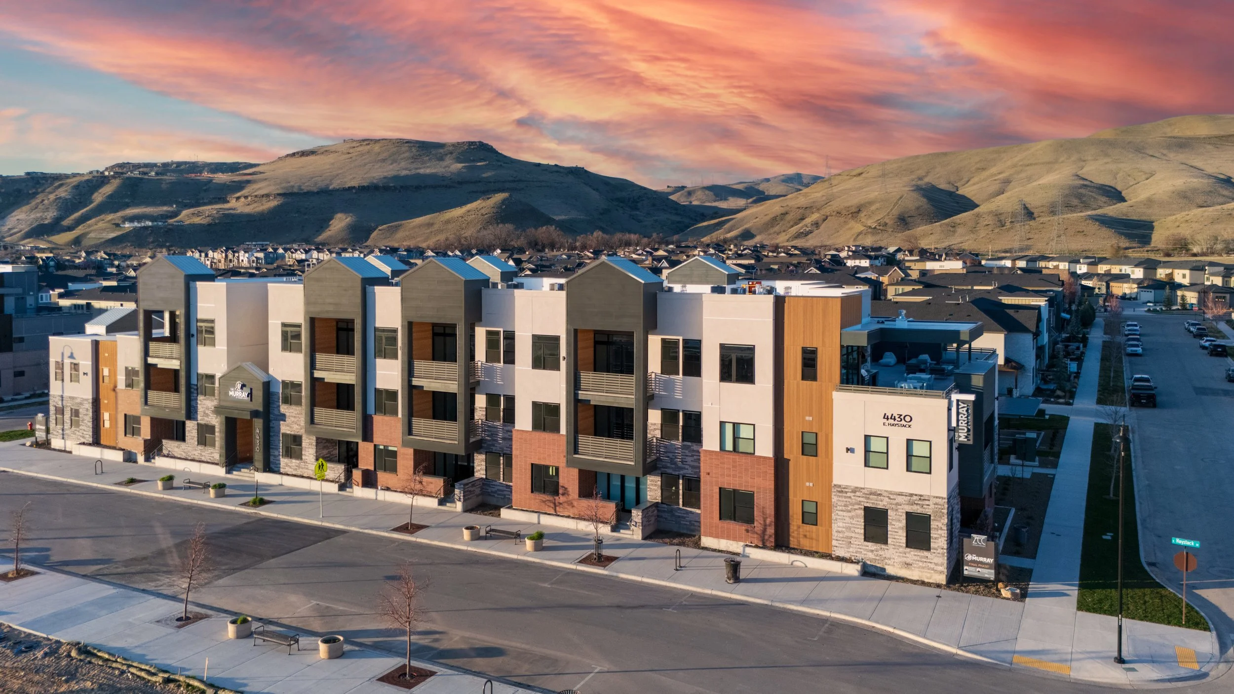 Modern Murray residences at twilight with warm interior glow, set against the Boise foothills under a fading evening sky