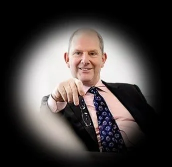 A smiling man in a business suit with a patterned tie, pointing towards the camera that knows a lot about the card payments industry, building businesses and raising capital.