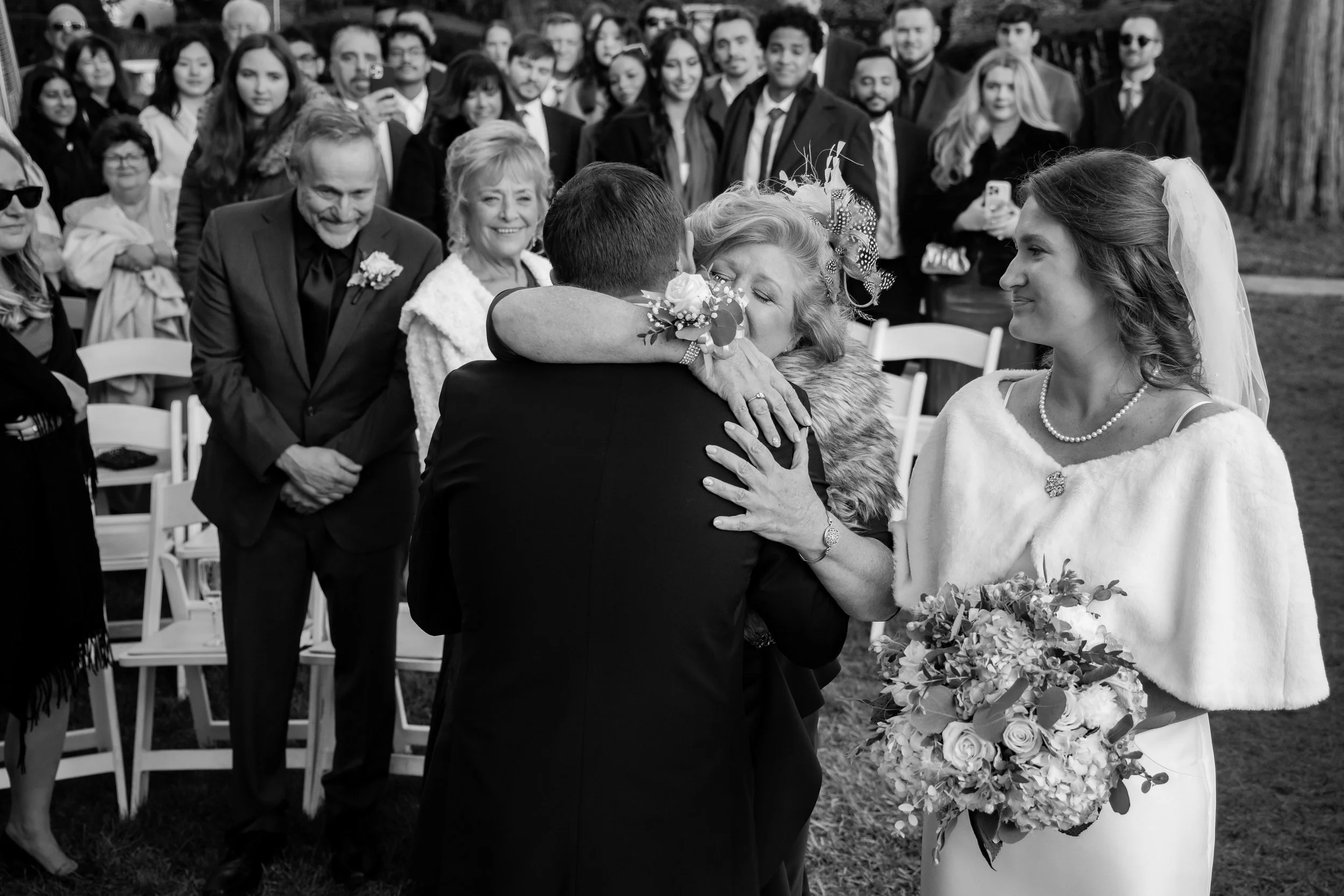 Mother of the bride hugs the groom as she gives her daughter away