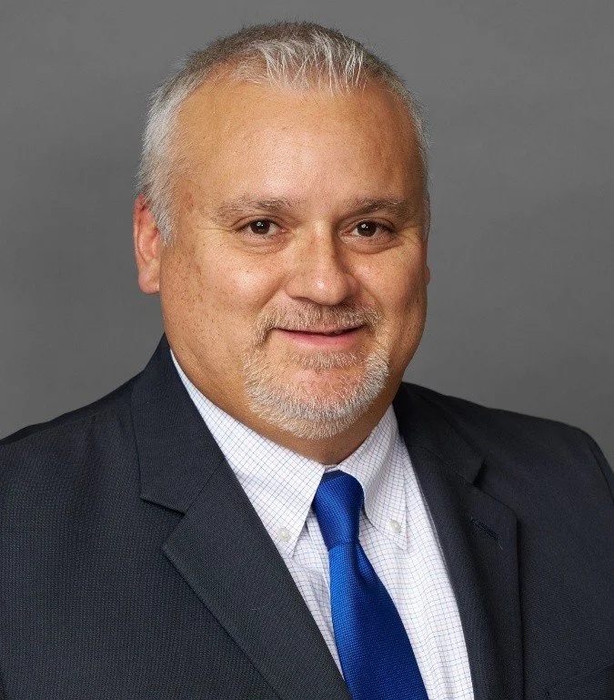 Man with very short hair wearing suit jacket and tie