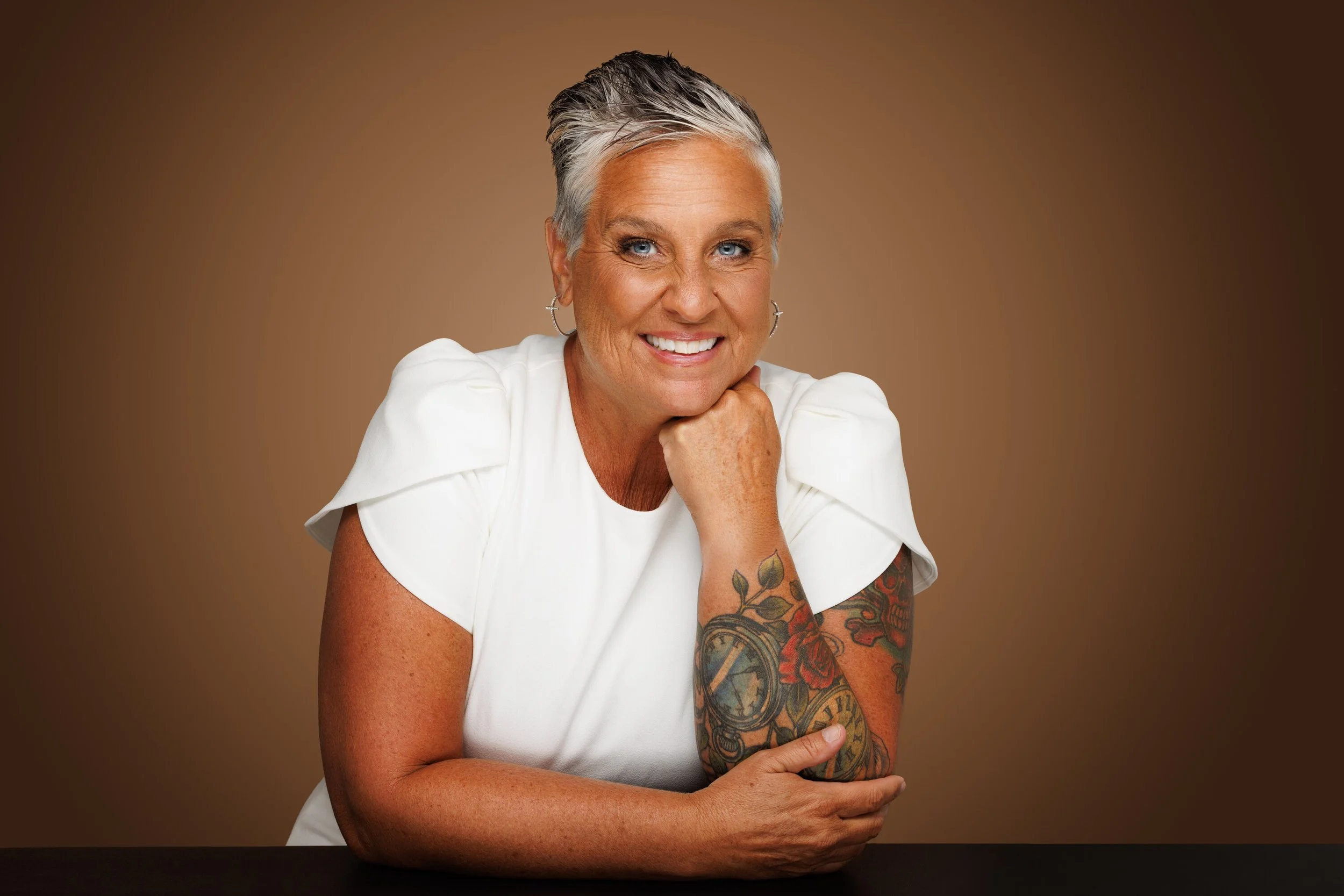 Smiling woman with short hair, hand to chin